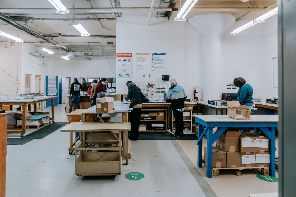 Plusieurs membres de l'équipe de travail dans l'aire de travail de l'Atelier majuscule