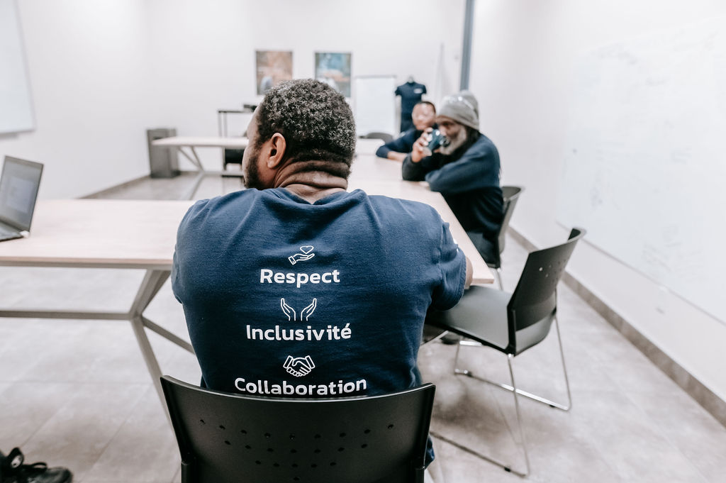 Salle de réunion chez Formétal avec un travailleur qui porte un t-shirt avec les mots Respect, Inclusivité et Collaboration.